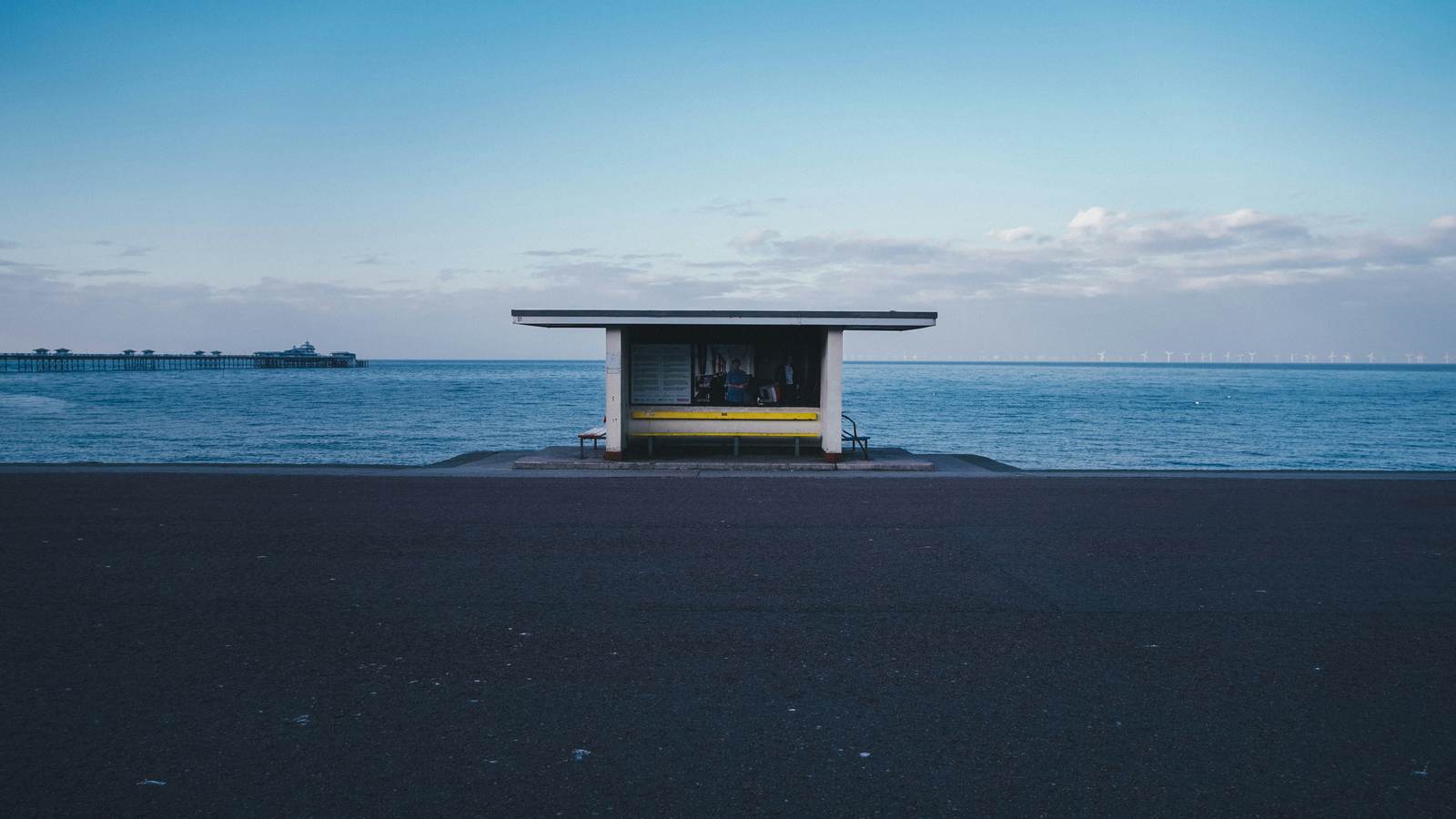 An empty seafront shelter overlooking the sea at dusk